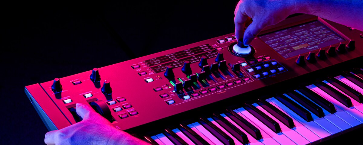 Image representing the CONTROL feature, showing a person operating the Super Knob on a synthesizer with dramatic lighting