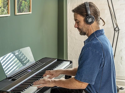 A person using headphones while playing the P-525