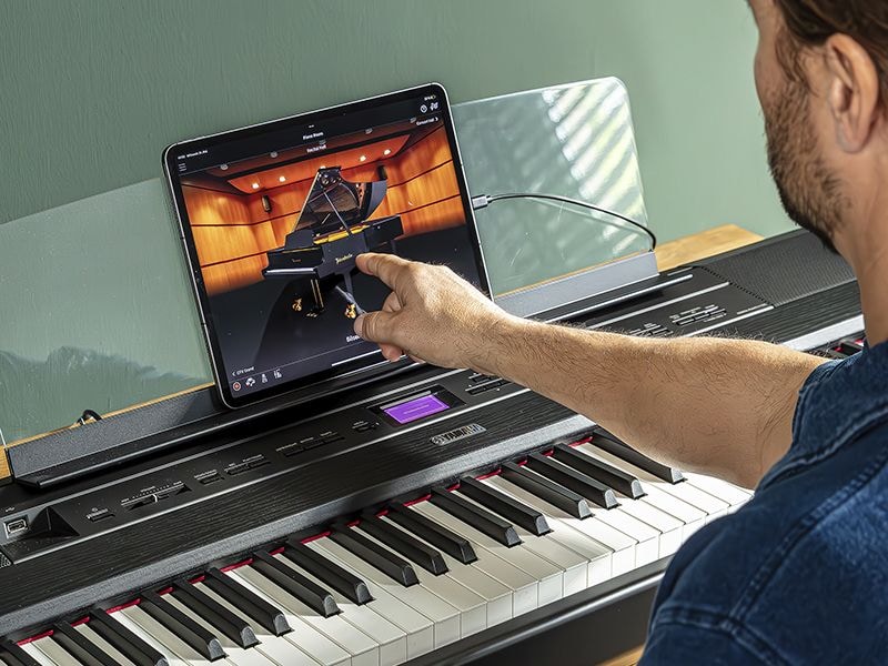 The Yamaha “Smart Pianist” app icon, together with a tablet placed on the music stand of the　P-525