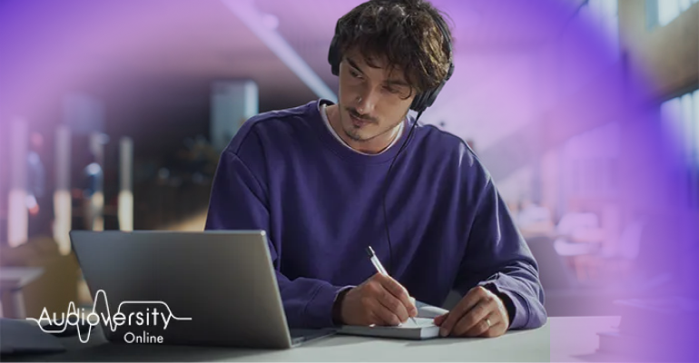 โลโก้การฝึกอบรมการศึกษาทางด้านเสียงแบบออนไลน์และแสงออร่าอยู่ด้านหลังชายคนหนึ่งที่กำลังโฟกัสอยู่กับการฝึกอบรมออนไลน์