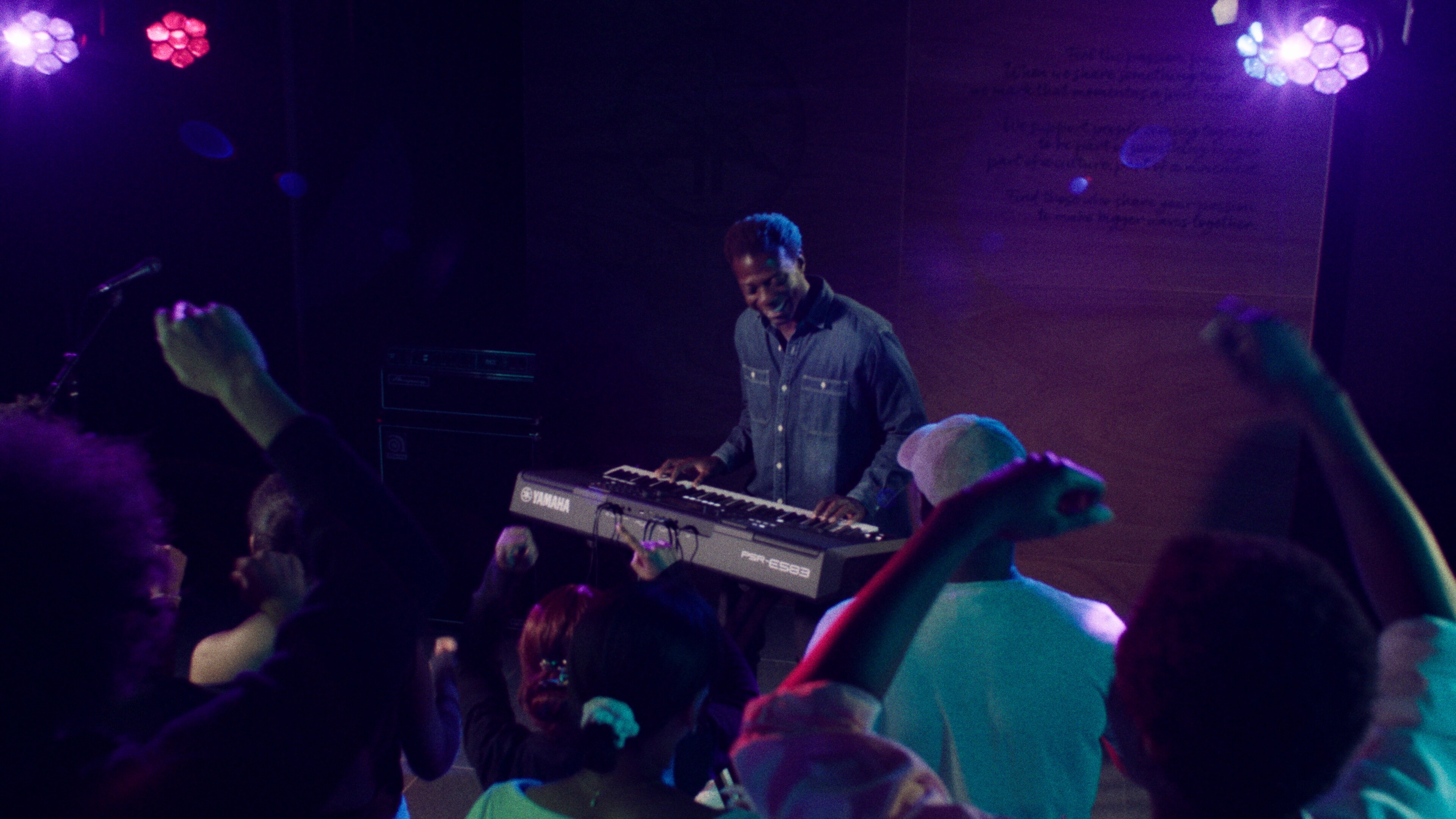 ภาพคนขณะกำลังเล่นคีย์บอร์ดแบบพกพารุ่น PSR-E583 ของ Yamaha พร้อมกับสวมหูฟัง