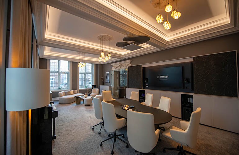 ภาพห้องประชุมสถานที่ฝึกอบรมในลอนดอน พร้อมโต๊ะ ที่นั่ง และหน้าจอแสดงผล