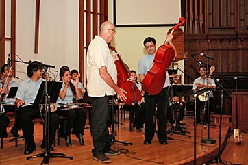 Mr. Barg presents the eight Yamaha cellos to Maestro Favio Chavez of the Recycled Orchestra of Paraguay (Photo: imillerphoto.com)